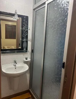 a bathroom with a sink and a glass shower door at Appt á louer TF2 in Marrakech