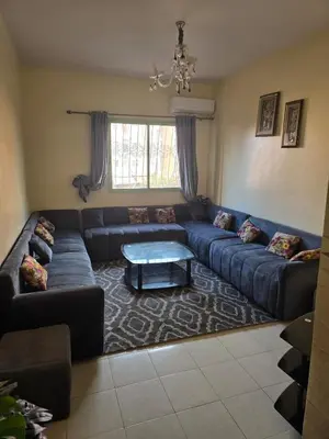 a living room with a blue couch and a table at Beautiful comfortable apartment in a secure residence in Marrakech