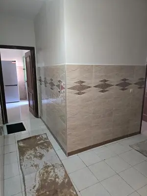 a bathroom with a shower with a tile wall at Beautiful comfortable apartment in a secure residence in Marrakech