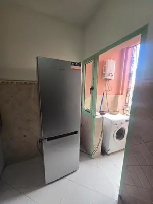 a kitchen with a refrigerator and a washing machine at Beautiful comfortable apartment in a secure residence in Marrakech