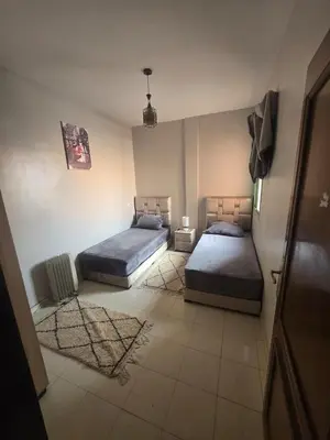 a room with two beds in a room at Beautiful comfortable apartment in a secure residence in Marrakech