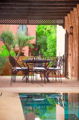 a patio with a table and chairs next to a pool at Villa Aylal in Marrakech