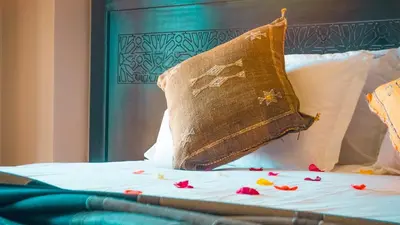a pillow on a bed with flowers on it at Villa Aylal in Marrakech