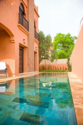 a swimming pool in front of a building at Villa Aylal in Marrakech