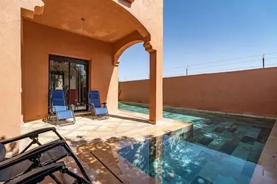 a house with a swimming pool and two chairs at Villa Aylal in Marrakech
