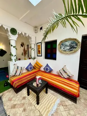 a living room with a couch and a table at Riad Iklil hcekarram in Marrakech