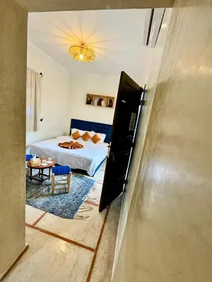 a bedroom with a bed and a room with a table at Riad Iklil hcekarram in Marrakech