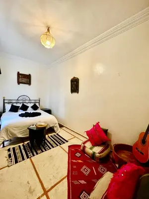 a bedroom with a bed and a guitar in it at Riad Iklil hcekarram in Marrakech