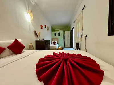 a red bow on a white bed in a room at Riad Iklil hcekarram in Marrakech