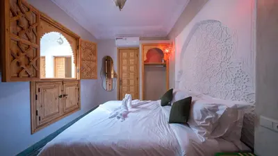 a bedroom with a white bed and a window at Riad Dreams Med in Marrakech