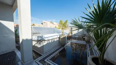 a balcony with a table and chairs and plants at Riad Dreams Med in Marrakech