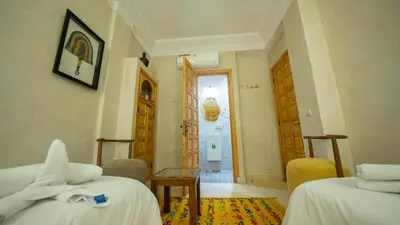 a hotel room with two beds and a hallway at Riad Dreams Med in Marrakech