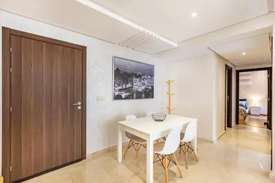 a white dining room with a white table and chairs at Résidence jnan ali 4 Marrakech in Marrakech