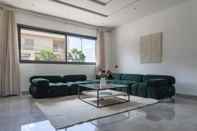 a living room with a green couch and a table at Villa Sunstone Marrakech in Marrakech