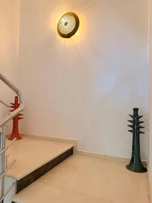 a room with a staircase and a light on the wall at Vibrant Modern House, 20 Min from Gueliz & Airport in Marrakech