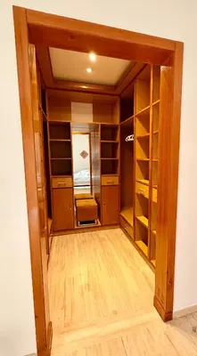 a walk in closet with wooden doors and shelves at Vibrant Modern House, 20 Min from Gueliz & Airport in Marrakech