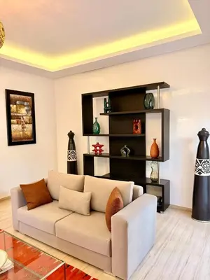 a living room with a white couch and a shelf at Vibrant Modern House, 20 Min from Gueliz & Airport in Marrakech