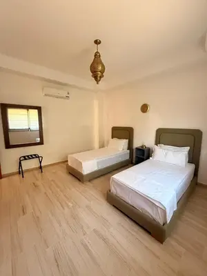 a bedroom with two beds and a chandelier at Vibrant Modern House, 20 Min from Gueliz & Airport in Marrakech