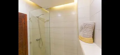 a bathroom with a shower and a towel at Modern 3-Bed retreat in Gueliz near Train station in Marrakech