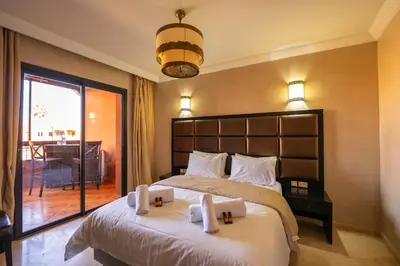 a bedroom with a large bed with towels on it at River Palm, bel appartement 2 ch Piscine résidence in Marrakech