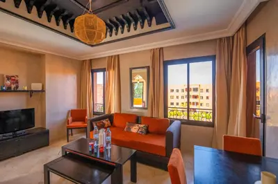 a living room with a couch and a tv at River Palm, bel appartement 2 ch Piscine résidence in Marrakech