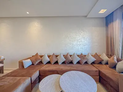 a living room with a large couch with pillows at Prestigia Argan 2Ch Piscine et Parking 6pax in Marrakech