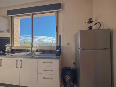 a kitchen with a refrigerator and a window at Prestigia Argan 2Ch Piscine et Parking 6pax in Marrakech
