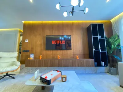 a living room with a television and a suitcase on a table at Hermès home in Marrakech