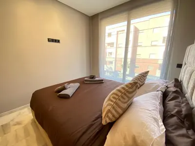 a bedroom with a bed with two slippers on it at Hermès home in Marrakech