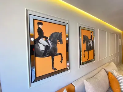 a living room with three paintings of a woman riding a horse at Hermès home in Marrakech