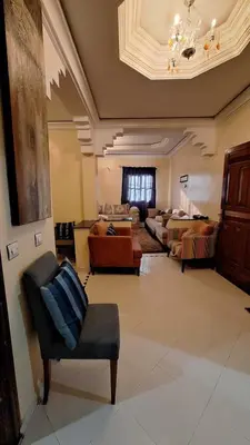a large living room with couches and a chandelier at Espacieuse in Marrakech