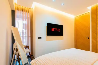 a bedroom with a bed and a tv on the wall at Quiet & Secure Apt - Fast WiFi - Central Area in Marrakech