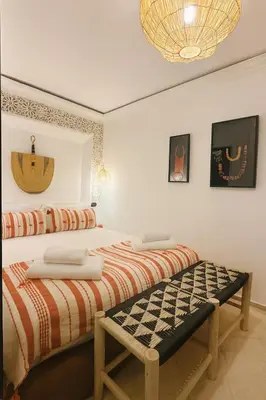 a bedroom with two beds and a chandelier at Riad chic Suite élégante au coeur de Marrakech in Marrakech