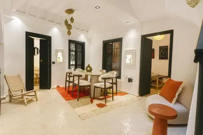 a living room with a table and chairs at Riad chic Suite élégante au coeur de Marrakech in Marrakech