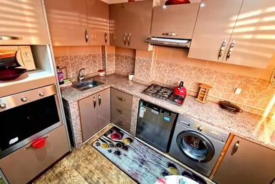 a small kitchen with a washing machine and a sink at Cozy apartment, traditional style, mountain view in Marrakech