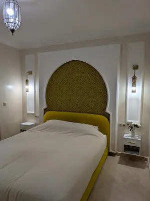 a bedroom with a large bed with a yellow headboard at Majorelle blue SPA retreat in Marrakech