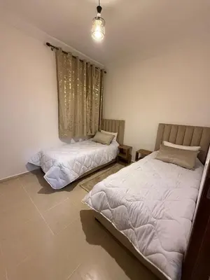 a bedroom with two beds and a window at Atlas view in Marrakech