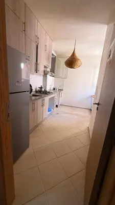 a kitchen with white cabinets and a tile floor at Atlas view apartement in Marrakech