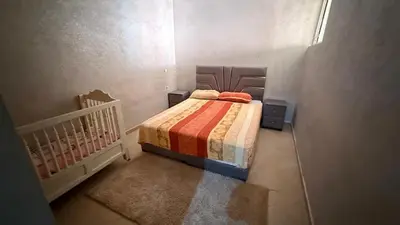 a small bedroom with a bed and a crib at Atlas view apartement in Marrakech