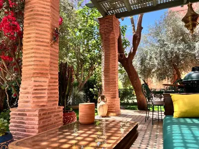 a patio with a brick pillar and a table at Eden Palmyra in Marrakech