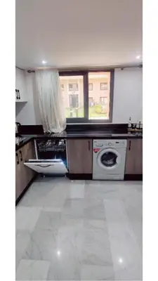 a kitchen with a washing machine and a window at Modern Duplex Apartment in Marrakech for family only - Comfortable Quiet in Marrakech