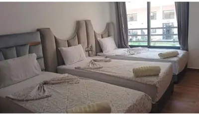 three beds in a room with a large window at Modern Duplex Apartment in Marrakech for family only - Comfortable Quiet in Marrakech