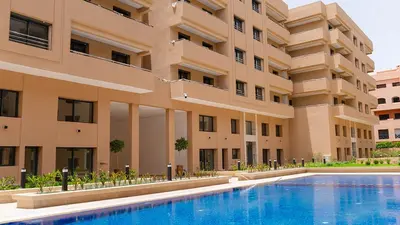 an external view of a building with a swimming pool at Modern Duplex Apartment in Marrakech for family only - Comfortable Quiet in Marrakech
