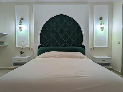 a bedroom with a large bed with a green headboard at Majorelle green Spa Suite in Marrakech