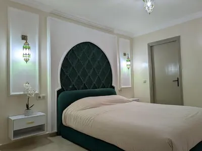 a bedroom with a large bed with a green headboard at Majorelle green Spa Suite in Marrakech