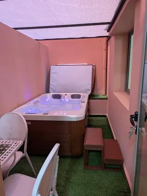 a hot tub in a room with a table and chairs at Majorelle green Spa Suite in Marrakech
