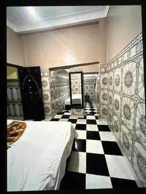 a bedroom with a black and white checkered floor at Hôtel Zagora sur in Marrakech