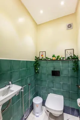 a green tiled bathroom with a toilet and a sink at Harmony Elegance and Comfort near Gueliz in Marrakech