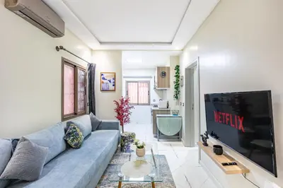 a living room with a blue couch and a flat screen tv at Harmony Elegance and Comfort near Gueliz in Marrakech