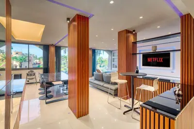 a living room with a tv and a table and chairs at Luxury Apartment in Central Hivernage in Marrakech